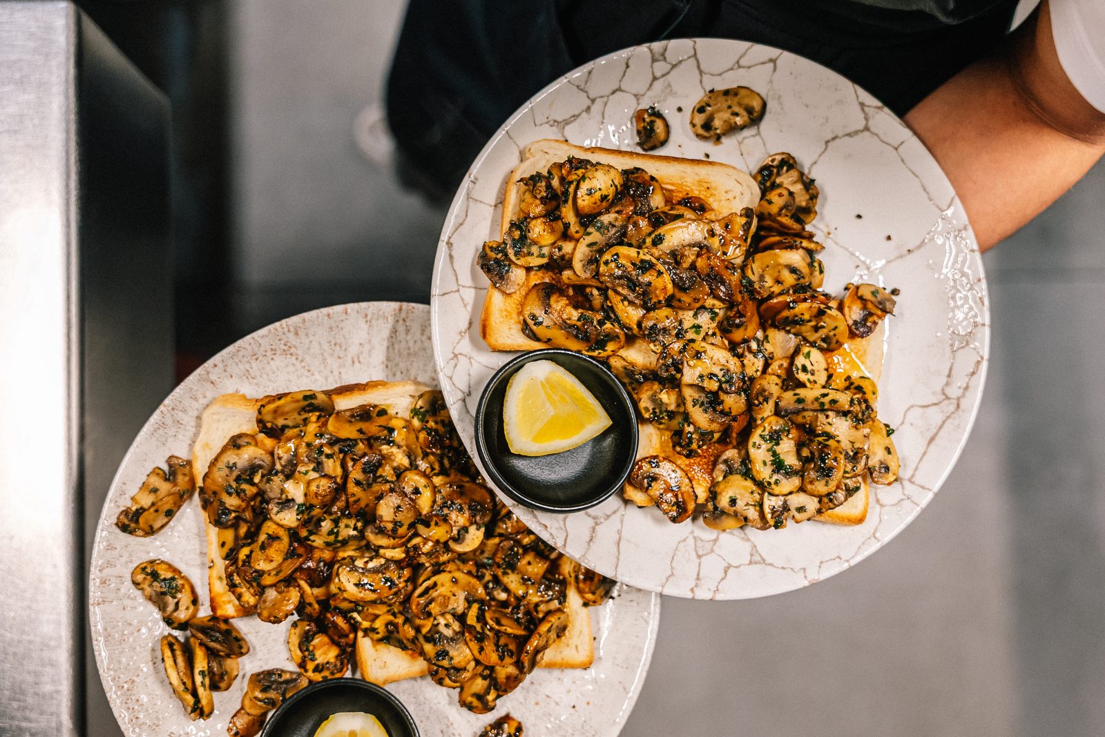 Garlic mushrooms on toast with a wedge of lemon.