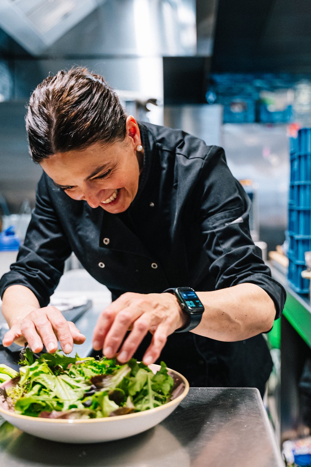 Juliette's chef plating a fresh salad in the kitchen.